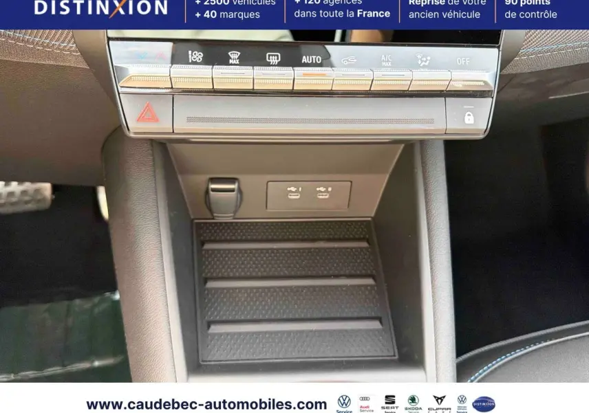 Vue rapprochée de la console centrale noire de la Renault Symbioz E-Tech avec commandes climatisation et ports USB visibles.