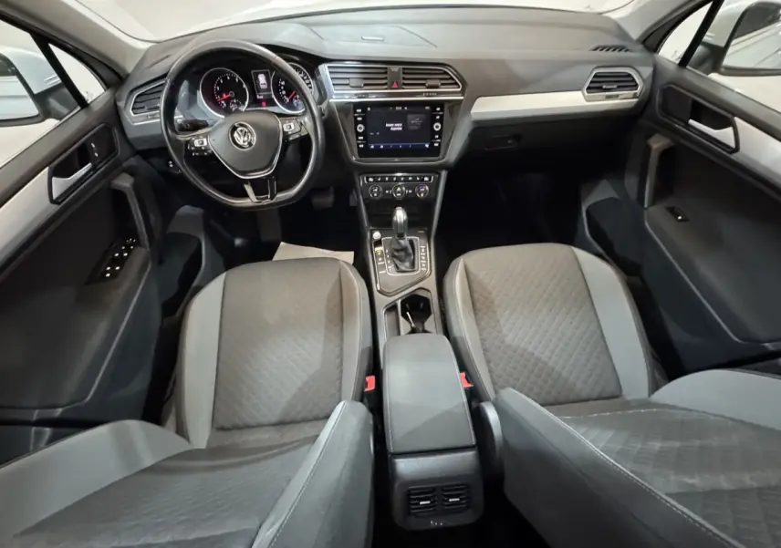 Intérieur du Volkswagen Tiguan 2020 vu de face, montrant tableau de bord, écran tactile et sièges gris.