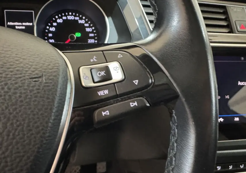 Gros plan sur le volant cuir noir du Volkswagen Tiguan 1.5 TSI 2020 avec commandes multifonctions et tableau de bord visible.