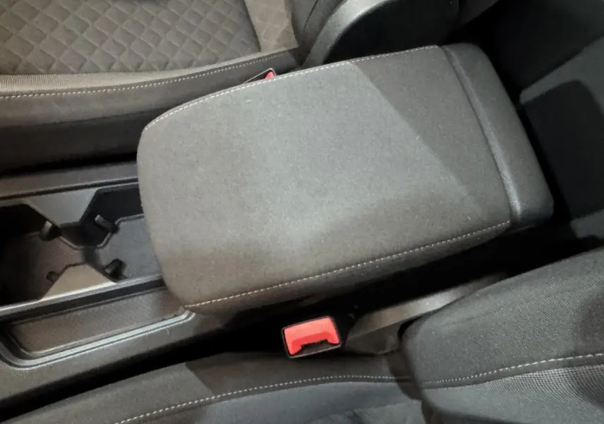 Vue rapprochée de l'accoudoir central noir et des sièges avant en tissu gris du Volkswagen Tiguan 2020 Confortline.