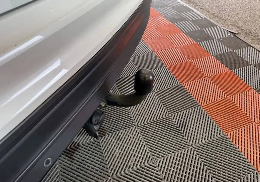 Gros plan sur l'attelage de remorque noir sous le pare-chocs arrière blanc du Volkswagen Tiguan 2020.