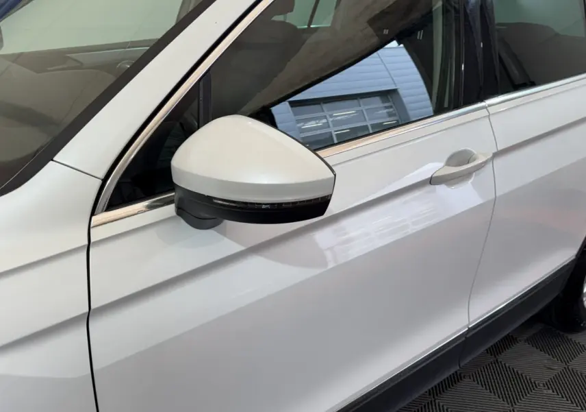 Vue rapprochée du côté gauche blanc du Volkswagen Tiguan 2020, mettant en valeur le rétroviseur avec clignotant intégré.
