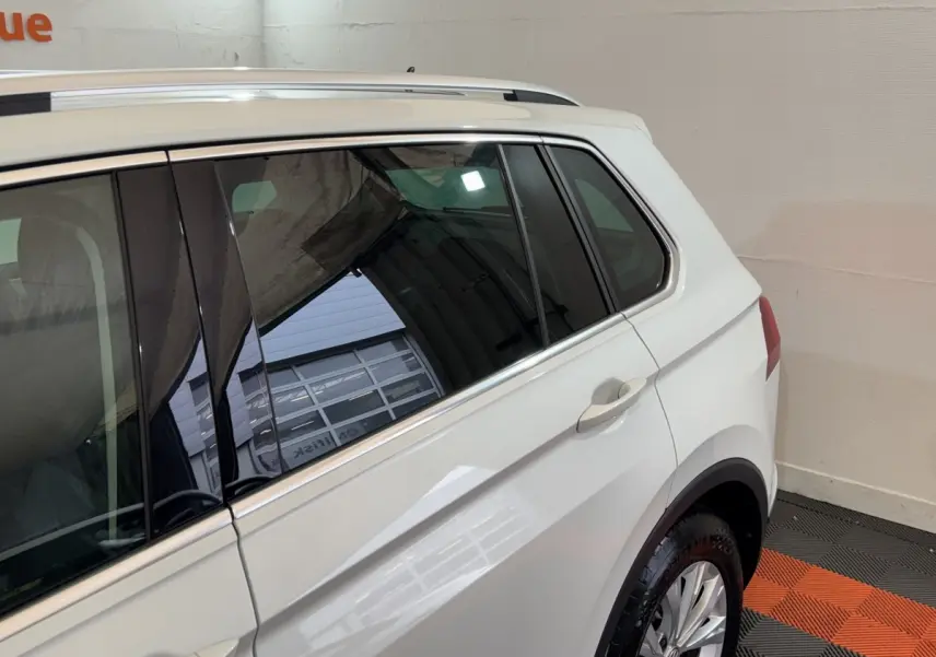 Vue côté droit arrière du Volkswagen Tiguan blanc 2020 avec vitres teintées et jantes alliage.