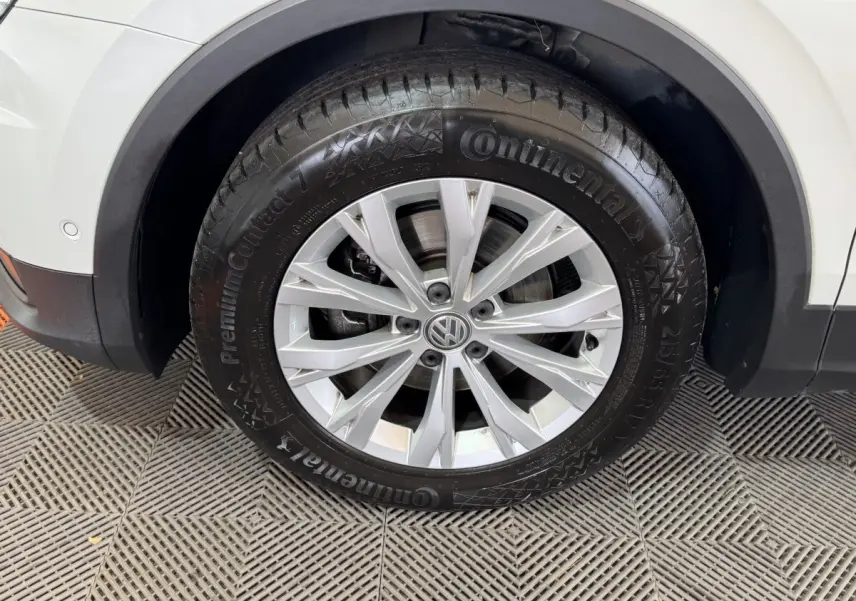 Gros plan sur la roue avant droite du Volkswagen Tiguan blanc, avec jante alliage argentée et pneu Continental.