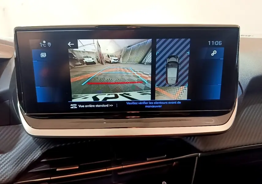 Écran tactile central de la Peugeot 208 jaune, affichant la caméra de recul et vue 360° intérieure.