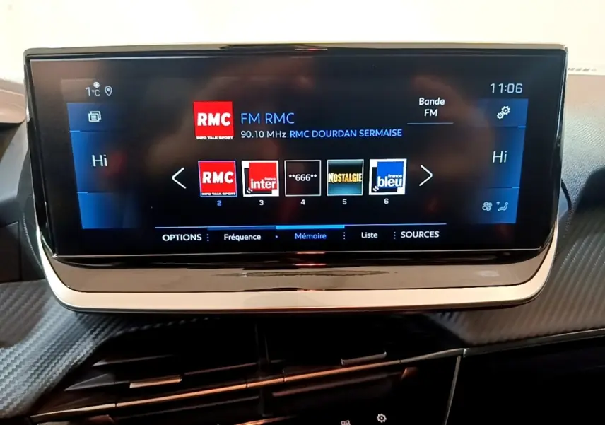 Écran tactile central 17,8 cm du tableau de bord d'une Peugeot 208, affichant les stations radio FM.
