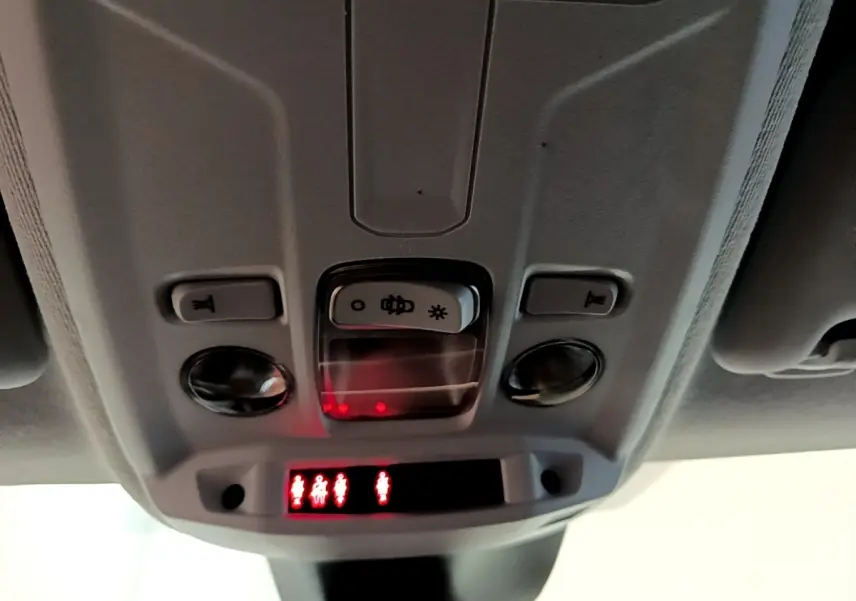 Détail du plafonnier intérieur avec commandes d’éclairage et indicateurs de ceinture sur Peugeot 208 jaune.