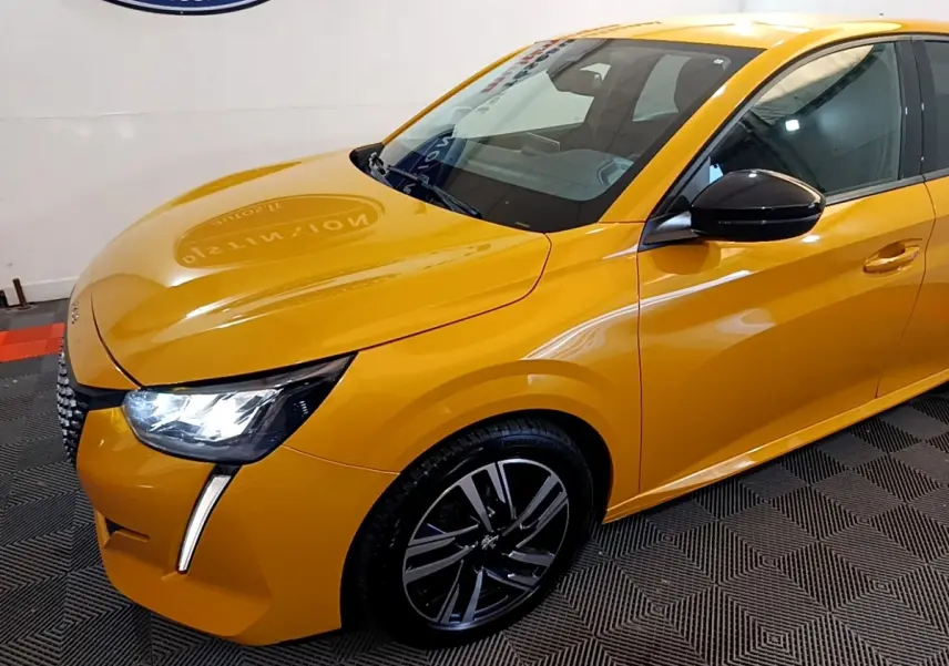 Vue 3/4 avant droite d'une Peugeot 208 jaune vif avec phares LED et jantes alliage noires.
