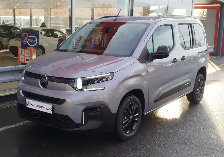 Citroën Berlingo gris acier vu en 3/4 avant droit, avec jantes noires et phares LED allumés.