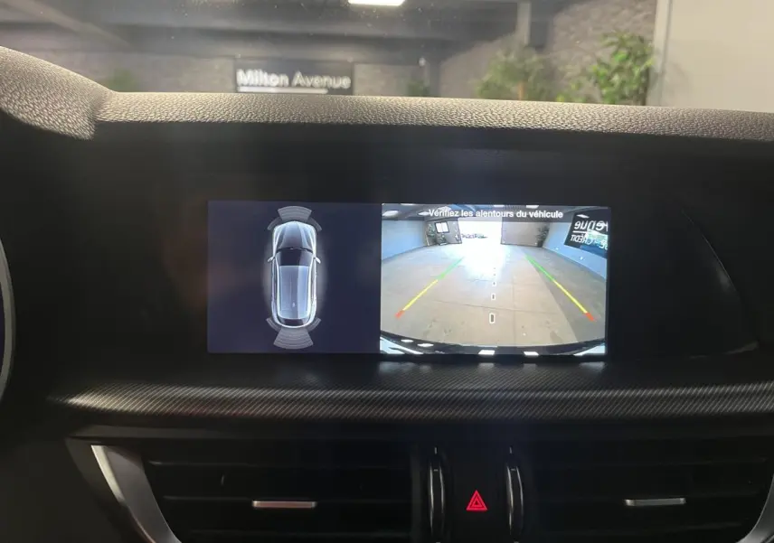 Écran central de l'Alfa Romeo Stelvio 2024 affichant la caméra de recul et l'aide au stationnement en intérieur.