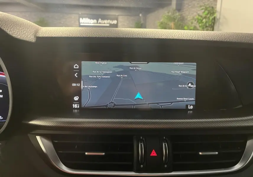 Vue intérieure centrée sur l'écran tactile de navigation du tableau de bord de l'Alfa Romeo Stelvio noir 2024.