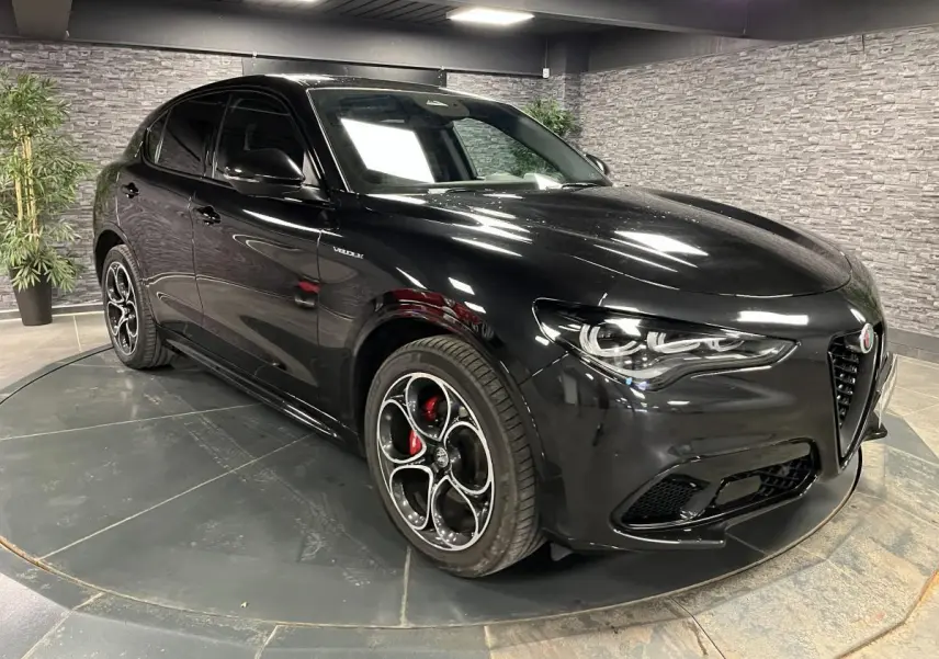 Alfa Romeo Stelvio Veloce noir, vue 3/4 avant droit, jantes alliage 20 pouces et étriers de freins rouges visibles.