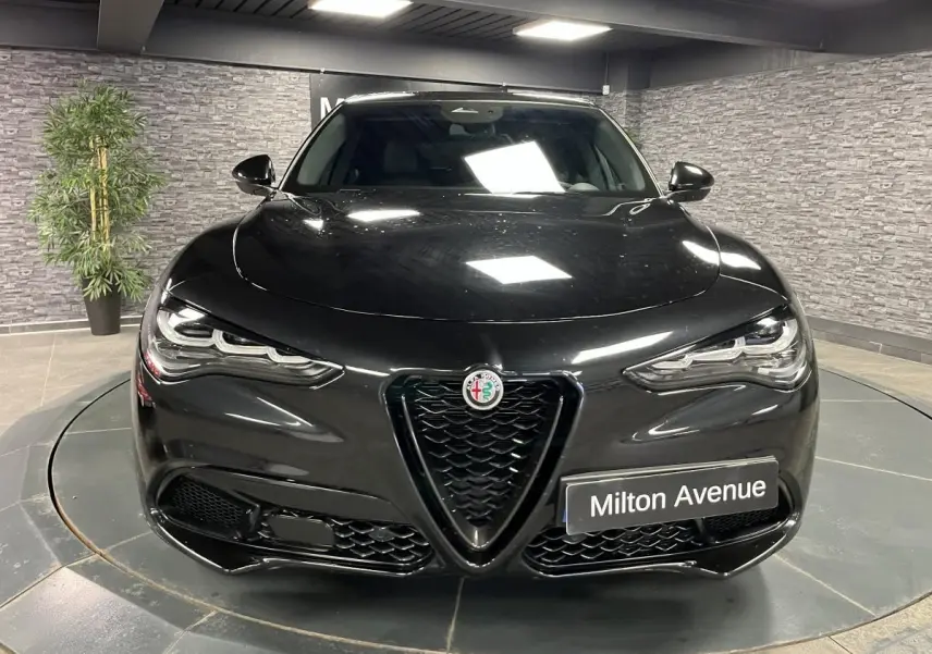 Vue avant d'un Alfa Romeo Stelvio 2.2 D Veloce noir Vulcano avec calandre en V et phares LED distinctifs.