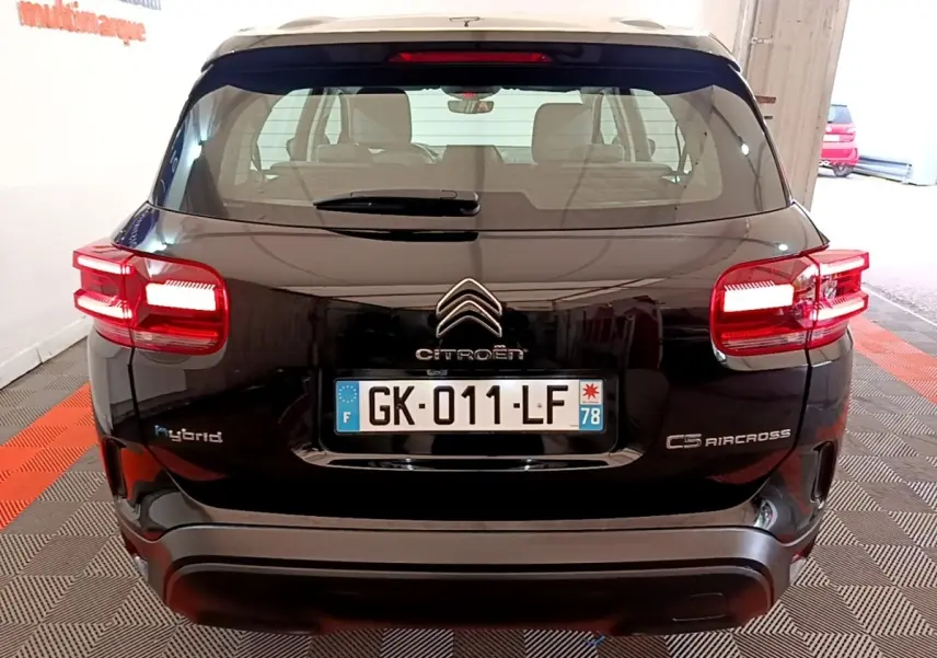 Vue arrière d'un Citroën C5 Aircross hybride rechargeable noir, avec feux arrière allumés et plaques d'immatriculation visibles.