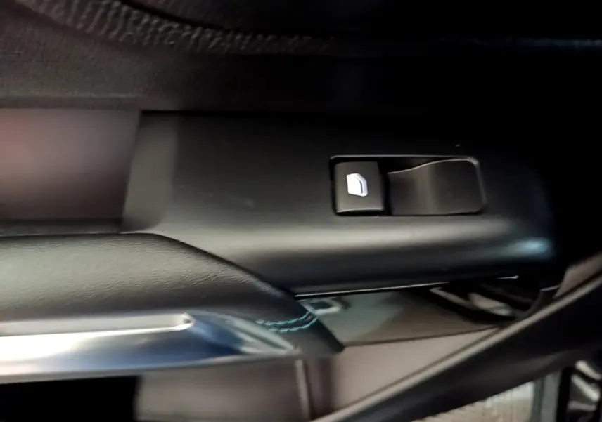 Détail de la commande de lève-vitre côté conducteur sur porte intérieure noire du Citroën C5 Aircross hybride 2022.