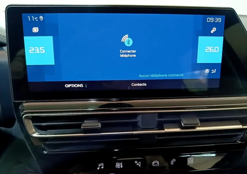 Écran tactile central du tableau de bord du Citroën C5 Aircross hybride noir, affichant la connexion Bluetooth et la climatisation.