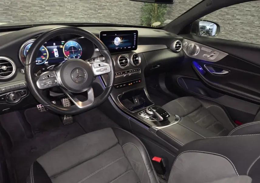 Vue intérieure côté conducteur de la Mercedes Classe C Coupé AMG Line 2019, avec combiné digital et ambiance noire élégante.