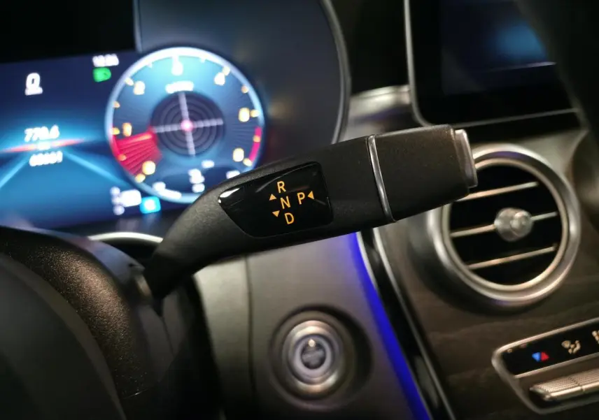 Gros plan sur le sélecteur de boîte automatique avec affichage des modes R, N, P, D dans l'habitacle gris d'une Mercedes Classe C Coupé.