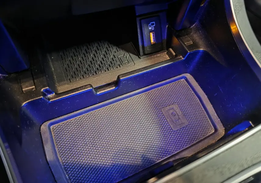 Gros plan sur le compartiment central avec recharge smartphone sans fil et prise USB dans la Mercedes Classe C Coupé gris.