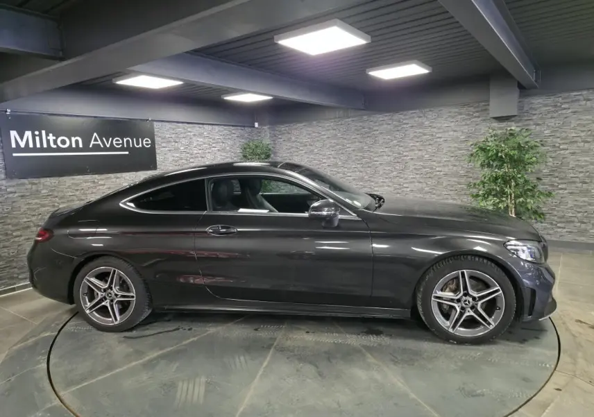 Mercedes Classe C Coupé gris métallisé vue de profil côté gauche avec jantes AMG 18 pouces à 5 branches doubles.
