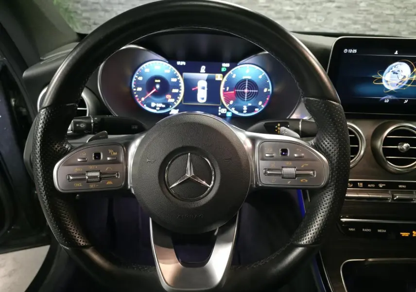 Vue rapprochée du volant cuir perforé et du combiné digital de la Mercedes Classe C Coupé gris 2019 AMG Line.