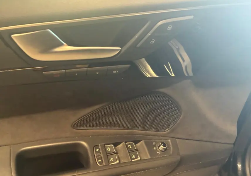 Détail de la porte côté conducteur de l'Audi A8 noire 2016, avec commandes de vitres et réglages des miroirs.