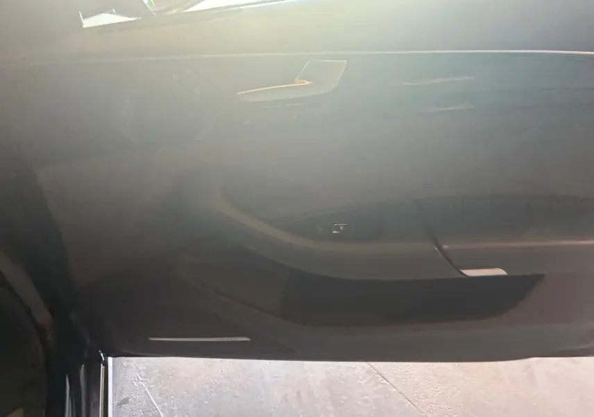 Vue intérieure de la porte côté conducteur de l'Audi A8 noire 2016, mettant en valeur les commandes et le design épuré.