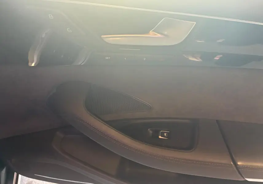 Détail de la porte intérieure côté conducteur de l'Audi A8 noire 2016, mettant en valeur la poignée et les commandes de réglage.