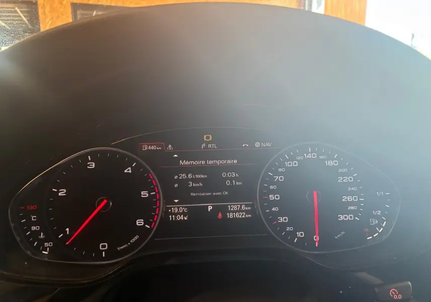 Vue rapprochée du tableau de bord numérique de l'Audi A8 noire 2016, affichant compte-tours et vitesse.