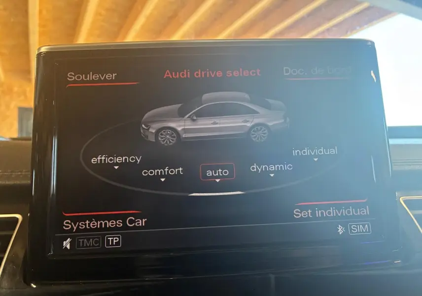 Écran central de l'Audi A8 2016 montrant le menu Audi drive select avec mode auto sélectionné, intérieur noir.