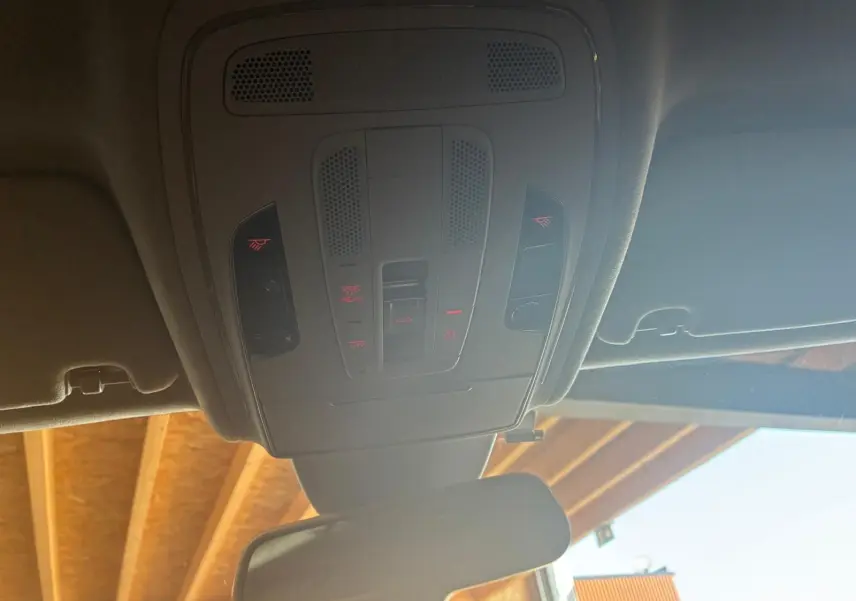 Vue intérieure du plafonnier avec commandes lumineuses et rétroviseur d’une Audi A8 noire de 2016.