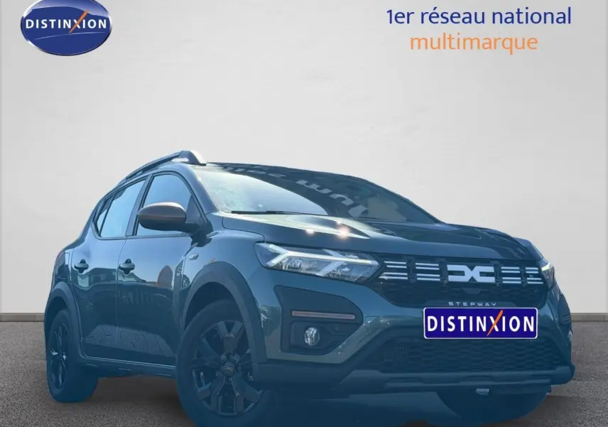 Vue 3/4 avant d'une Dacia Sandero Stepway 2025 vert cèdre métallisé avec jantes noires et barres de toit.