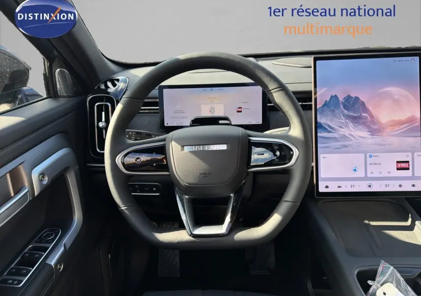 Vue intérieure centrée sur le volant JAECOO avec tableau de bord numérique et grand écran tactile vertical.