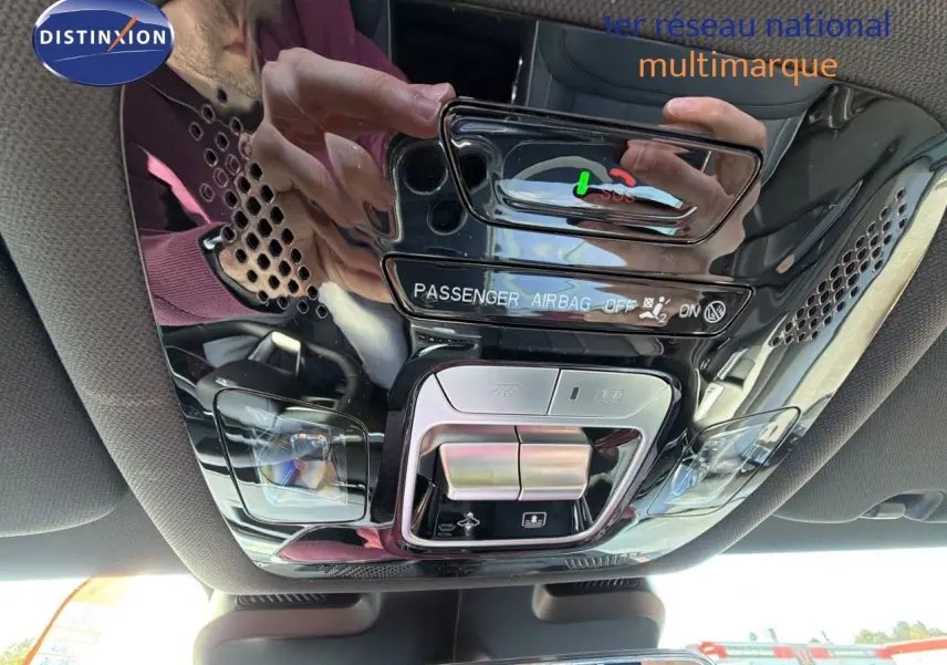 Vue en gros plan du plafonnier intérieur noir brillant du JAECOO J7 avec commandes d’éclairage et indicateur airbag passager.