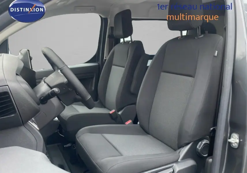 Vue intérieure côté conducteur du Citroën Jumpy cabine approfondie gris titane, montrant les sièges avant en tissu noir.