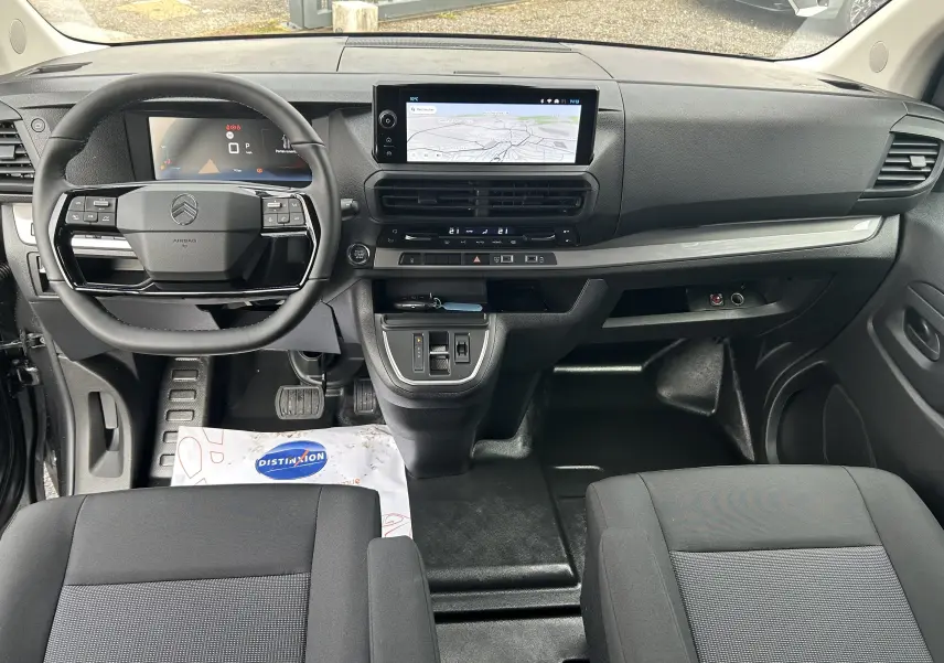 Vue intérieure avant du Citroën Jumpy cabine approfondie 2025, tableau de bord noir avec écran tactile central et volant multifonction.