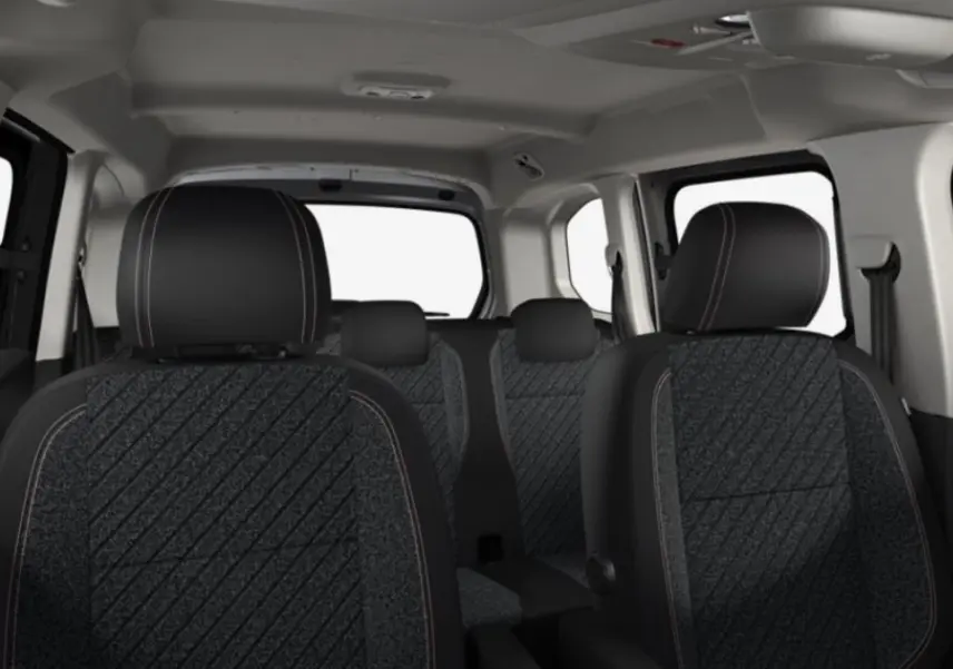 Vue intérieure du Peugeot Rifter gris acier 2026, montrant les sièges avant et arrière en tissu avec surpiqûres contrastées.