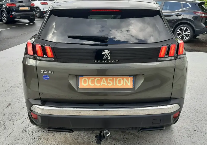 Vue arrière d’un Peugeot 3008 gris amazonite de 2019 avec feux LED et attelage visible sur parking.