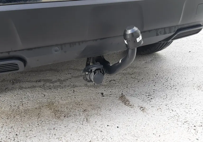 Gros plan sur l'attelage arrière noir du Peugeot 3008 gris Amazonite, mettant en valeur la prise électrique intégrée.