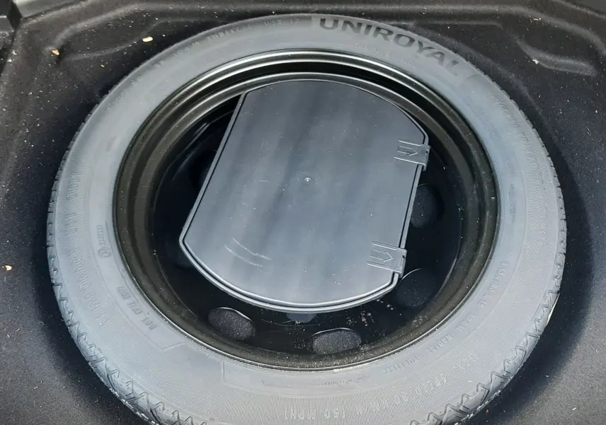 Roue de secours Uniroyal noire installée dans le coffre d'une Peugeot 3008 gris Amazonite, vue de dessus.