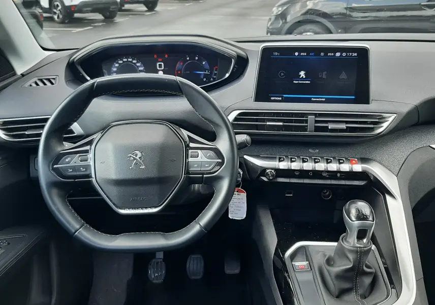 Vue intérieure frontale du poste de conduite du Peugeot 3008 gris Amazonite, avec volant compact et écran tactile central.