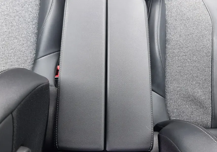 Vue plongeante sur l'accoudoir central en cuir noir et les sièges gris à tissu et cuir du Peugeot 3008 2019.