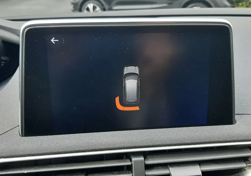 Vue intérieure de l'écran tactile du Peugeot 3008 gris Amazonite, affichant l'alerte de proximité arrière gauche.