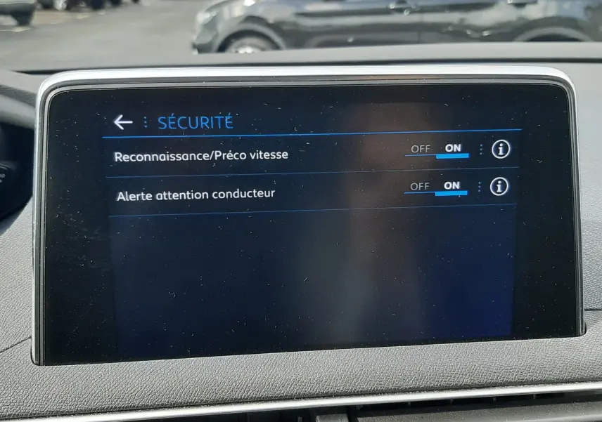 Écran central du tableau de bord du Peugeot 3008 gris Amazonite, affichant les options de sécurité activées.