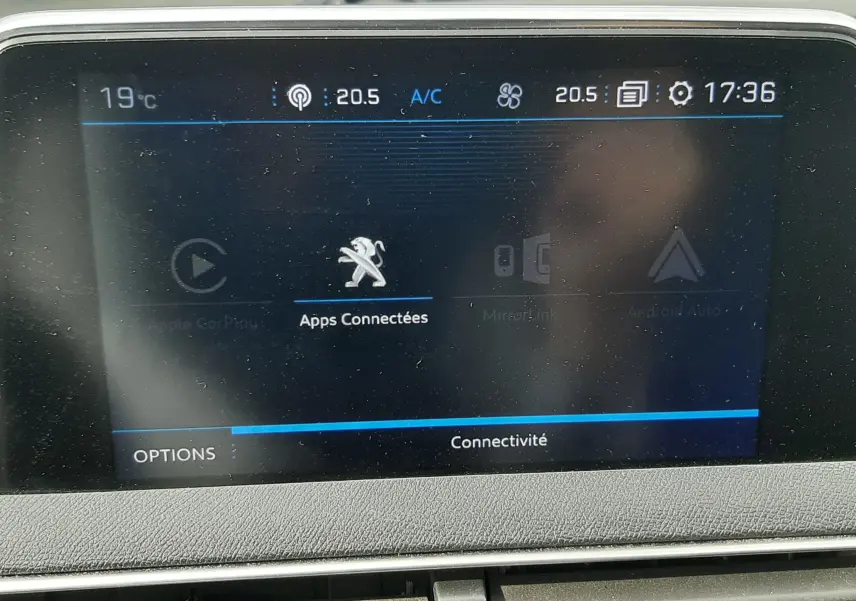 Écran tactile central du Peugeot 3008 gris Amazonite de 2019, affichant les options de connectivité et la température intérieure.