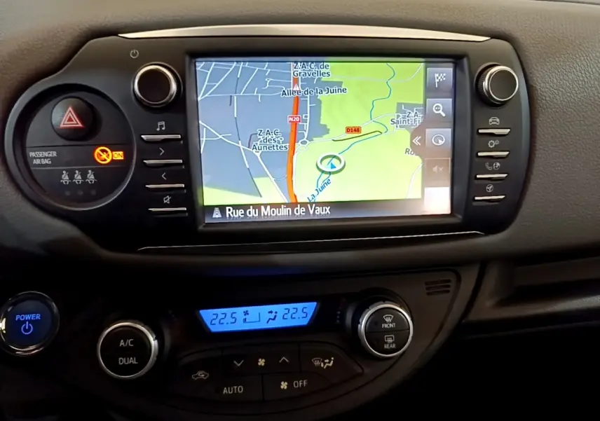 Vue rapprochée de l’écran tactile de navigation et de la console centrale noire de la Toyota Yaris blanche 2019.