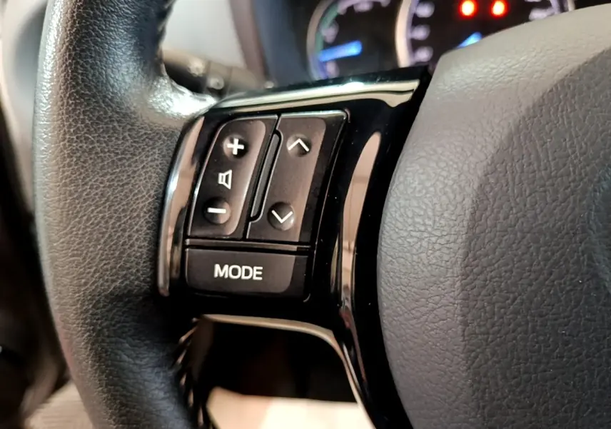 Gros plan sur le côté gauche du volant en cuir noir de la Toyota Yaris 2019 avec boutons de contrôle audio et mode.