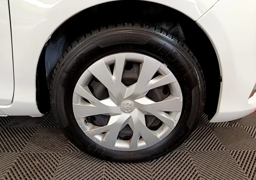 Gros plan sur la roue arrière droite blanche d'une Toyota Yaris 2019 avec enjoliveur gris et logo Toyota central.