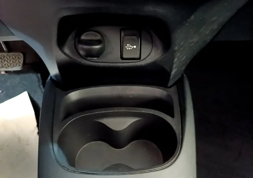 Vue rapprochée de la console centrale noire de la Toyota Yaris 2019, avec prise USB et porte-gobelets.
