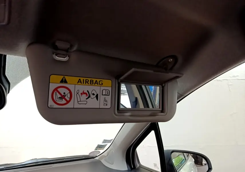 Intérieur côté conducteur de la Toyota Yaris blanche 2019, avec pare-soleil et miroir de courtoisie ouvert.